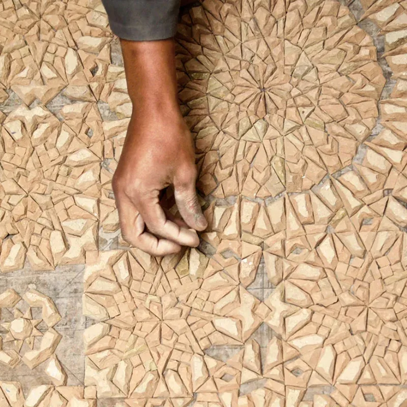 Hand-cut zellige pieces being assembled face down, piece by piece
